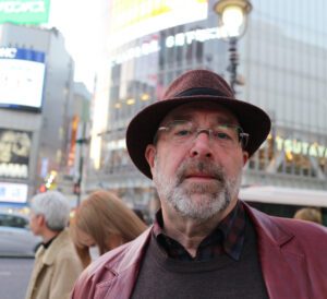 Man in a hat and glasses in a city