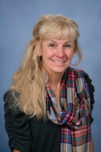 Smiling woman wearing a plaid scarf.